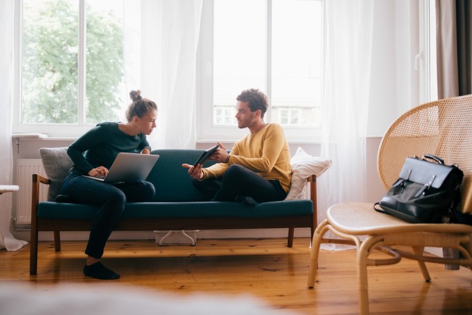 Mladi par u svom domu preko digitalnih uredjaja istražuje primere fišing kampanja