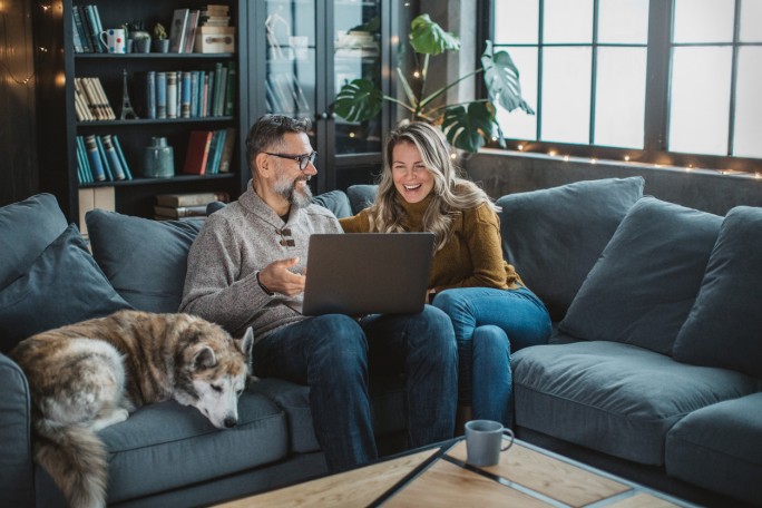 Mature couple at home using video call to talk with friends or family during pandemic isolation period.