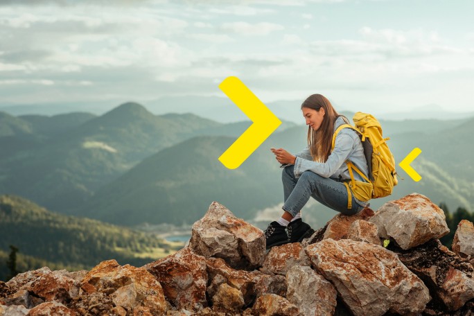 Mlada devojka na planinarenju preko telefona gleda iPortal Raiffeisen banke