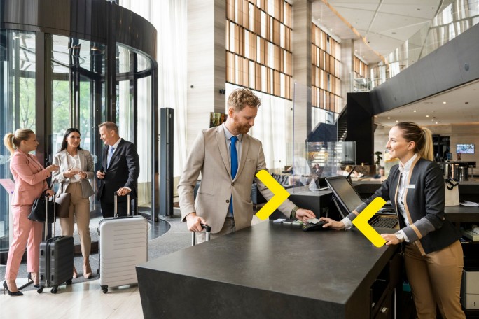 Čovek plaća hotel uz pomoć Biznis platne kartice Raiffeisen banke