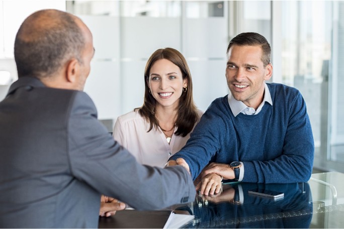 A satisfied customer shaking hands with a bank representative after the successful completion of the account switching procedure