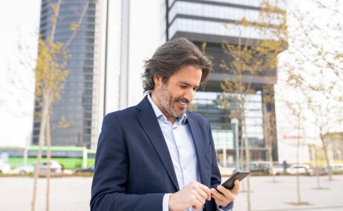 Čovek gleda u svom telefonu prikaz svih svojih kartica Raiffeisen banke