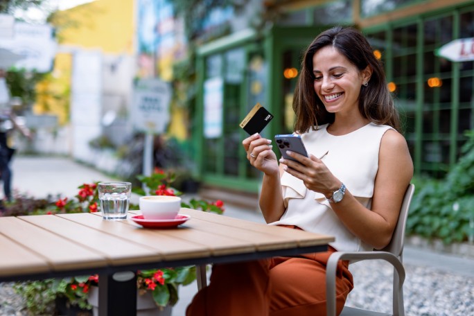 Žena u kafiću plaća račun uz pomoć Visa Gold kartice