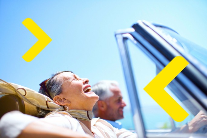 Srećan stariji par u kabrioletu uživa u slobodi i bezbrižnosti koju pružaju personalizovane usluge privatnog bankarstva