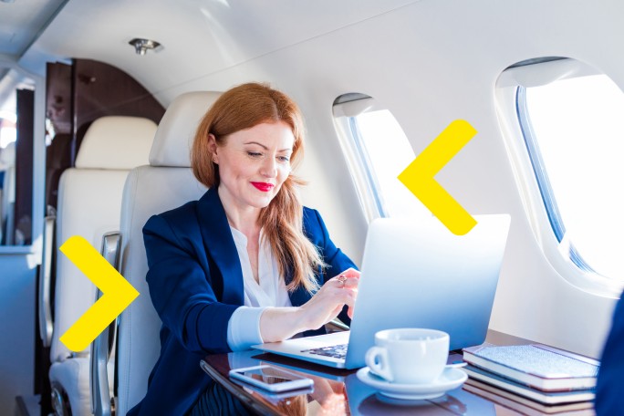 Poslovna žena koristi digitalne bankarske usluge u privatnom avionu uz privilegije koje pruža Visa Infinite kartica