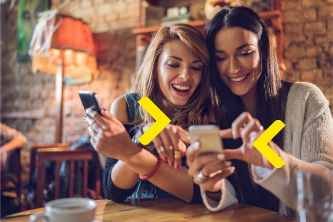 Dve devojke koriste Prenesi uslugu Raiffeisen banke