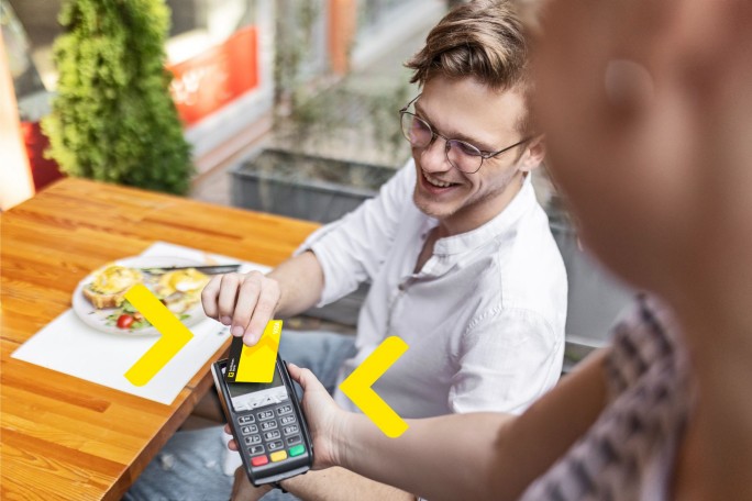 Mladi čovek koristi Visa debitnu karticu Raiffeisen banke za plaćanje