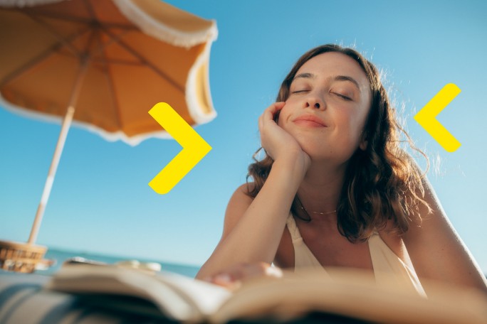 Žena čita knjigu na plaži i plaća kreditnom karticom Raiffeisen banke
