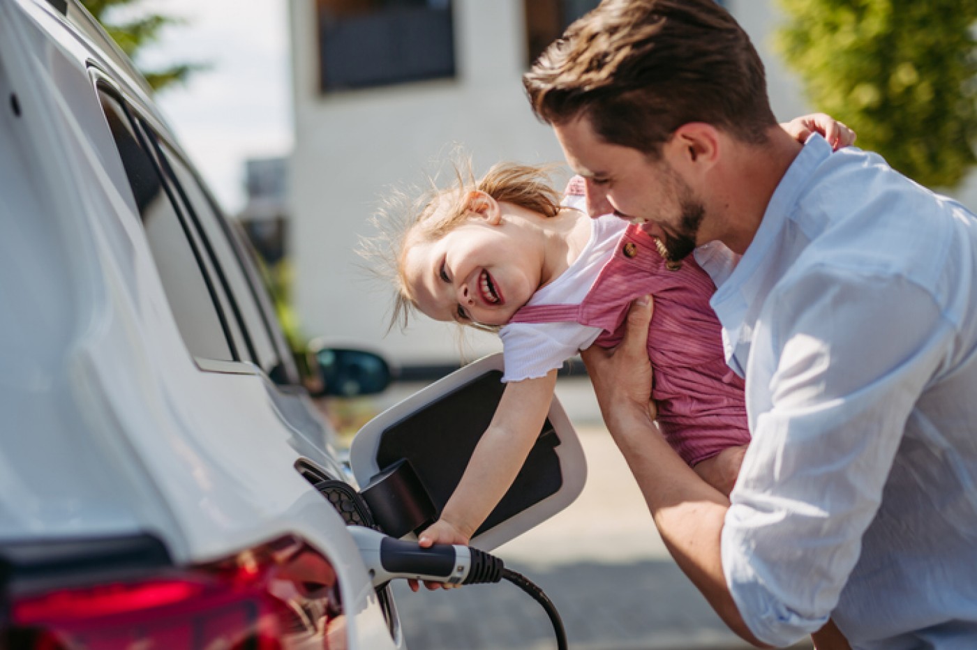 Tata i ćerka pune bateriju svom novom električnom vozilu kupljenom kreditom Raiffeisen banke