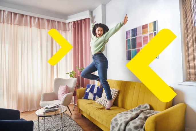 Mlada žena slavi useljenje u sopstveni dom kupljen uz povoljan stambeni kredit banke.