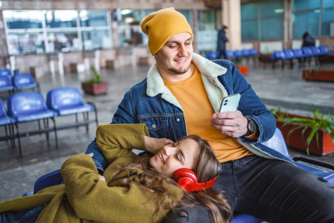 Mladi par na stanici preko telefona proverava svoj devizni račun Raiffeisen banke