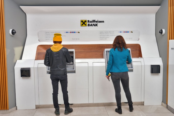 Dvoje ljudi vrši plaćanja i ostale transakcije na višenamenskim bankomatima