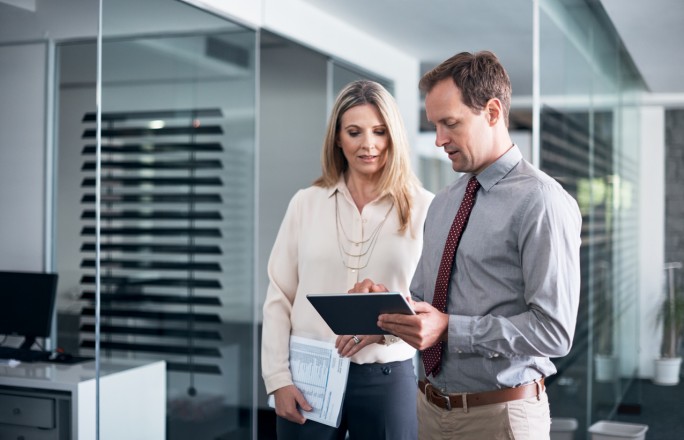 Bankar i žena na digitalnom uredjaju gledaju koji su tipovi POS terminala