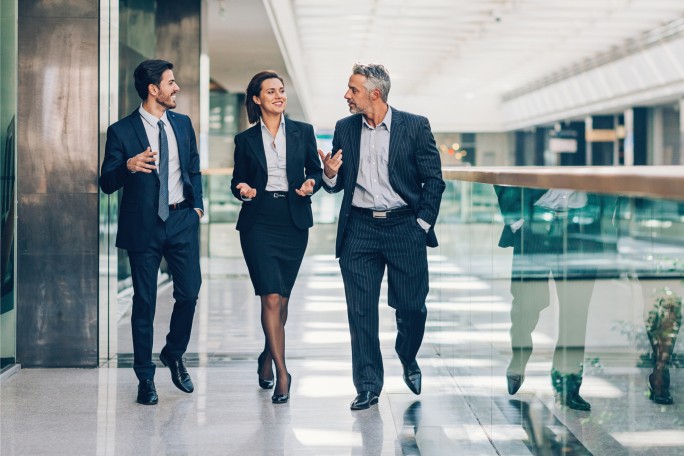 A professional business team walking in a modern office, representing how Raiffeisen Bank's digital solutions and 24/7 accessibility help companies improve their daily operations