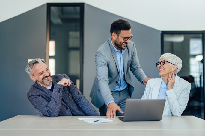 Novi klijenti u banci gledaju na laptopu pogodnosti za otvaranje prvog dinarskog računa