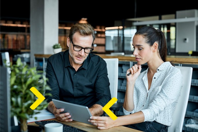 Stručnjaci za investiciono bankarstvo analiziraju kretanje portfolija i tržišne indikatore na digitalnom uređaju